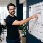 Fernando apontando para calendário no quadro branco — Calendário editorial com IA para PMEs